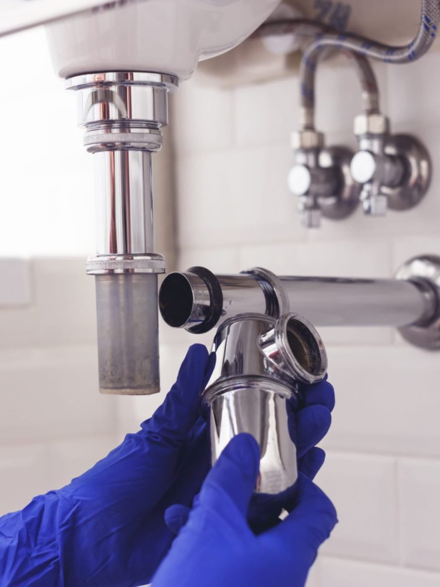 Plumber repairing a sink drain trap